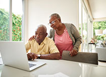 Photo of a couple looking at a laptop. Link to Life Stage Gift Planner Over Age 65 Situations.